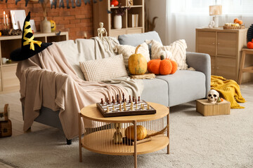 Poster - Interior of festive living room with grey sofa, pumpkins and Halloween decorations