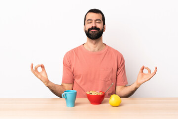 Wall Mural - Caucasian man having breakfast in a table in zen pose.