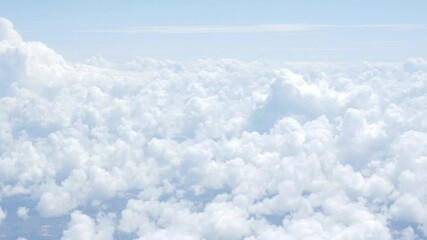 Wall Mural - view from plane over blue sky with white Fluffy clouds while flying through in sunny summer time.nature blue sky cloud and sun for Clean Environment, save energy or transportation holiday concept. 