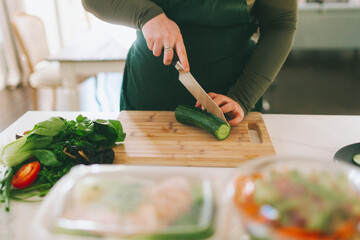 A woman preparing and cutting fresh vegetables.