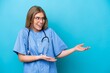 © luismolinero - Young surgeon doctor woman isolated on blue background with surprise facial expression