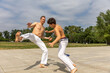 © rilueda - Teenager and middle aged man practicing capoeira , brazilian martial art