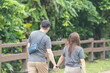 © Masakazu Tokashiki - Chinese Malaysian couple in their 30s walking closely together in a lush, water-filled park in Kuala Lumpur, Malaysia.