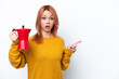 © luismolinero - Young Russian girl holding coffee pot isolated on white background surprised and pointing finger to the side