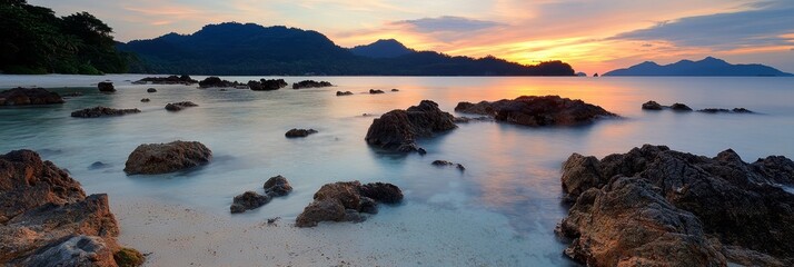 Wall Mural -  A sizable water expanse, featuring rocks in the foreground, and a distant mountain range beyond