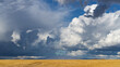 © Austockphoto - Dramatic storm clouds over a wide expanse of golden farmland
