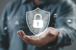 © Bordinthorn - A person demonstrating digital security with a hand gesture, showcasing a lock icon on a shield in a technology-focused environment.