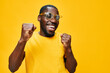 © SHOTPRIME STUDIO - Happy man celebrating joyfully in a bright yellow shirt and sunglasses against a vivid yellow background, expressing excitement and positivity, ideal for lifestyle and happiness themes