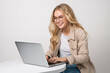 © luismolinero - Young pretty blonde girl over isolated white background working with a laptop