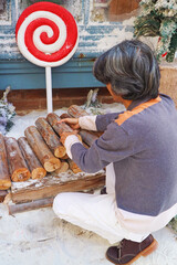 Wall Mural - People Preparing Firewood at the Christmas Decorated Backyard