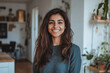 © Chari - Smiling woman in cozy home interior with plants and warm decor on a bright afternoon