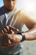 © JordaanExams/peopleimages.com - Training, smart watch and arm of man on beach for start of running, fitness and heart rate tracker. Race, exercise and marathon cardio with runner for wellness app, digital and sport performance