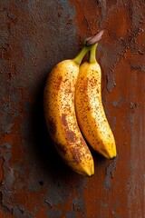 Poster -  Two ripe bananas atop a weathered metal table near a worn-out brick wall