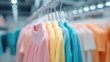 © JoxyAimages - A selection of pastel and brightly colored clothing hung on a rack in a store, emphasizing the variety and vibrancy of the clothing items available for shoppers.