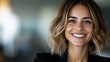 © JoxyAimages - A woman exuding happiness in a black blazer, with naturally styled hair and a radiant smile. Her energetic presence lights up the softly blurred office background.