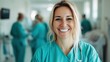 © JoxyAimages - A nurse with blonde hair wearing teal scrubs laughs joyfully in a hospital setting, epitomizing good spirits and a nurturing role in patient care environments.