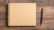 © medalinebow - Minimalist desk setup with a notebook and pen, topdown view, soft natural tones.