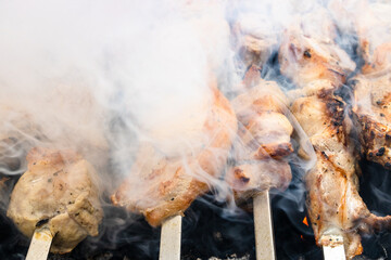 grilling skewered pieces of pork meat closeup