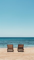 Wall Mural - Serene beachside scene  two lounge chairs on soft sand with tranquil sea and clear sky