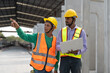 © Supachai - Asian male civil engineers wearing vest and helmet safety discussing foreman worker at construction site. Indian foreman with laptop working at factory making precast concrete wall.