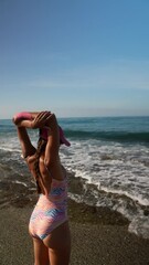 Wall Mural - Joyful Beach Day A Happy Girl Joyfully Playing by the Waves in the Sunlit Ocean