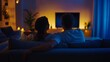 © Sasint - Couple relaxing on the couch in the evening, watching TV and enjoying a quiet moment together, with dim lighting and a calm vibe