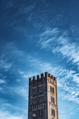 Ancient medieval tower stands out against a blue sky streaked with clouds