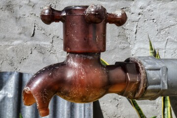 Broken plastic water faucet on blur background.