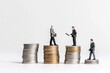 © Salander Studio - miniature business people standing on top of stacks of coins