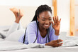 © Prostock-studio - Hello. Positive African American Woman Making Video Call Via Cellphone Waving Hand Lying In Bed At Home. Panorama, Selective Focus