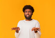 © Prostock-studio - Disgusted young black man feeling aversion and gesturing with hands over orange studio background, copy space