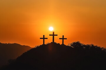 silhouette of crosses on a mountain and orange sky in the background