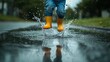 © SaviArt - Child jumping in a puddle with yellow rain boots on a rainy day