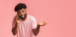 © Prostock-studio - I told you. Sceptic african american guy talking on mobile phone and gesturing, pink background, free space
