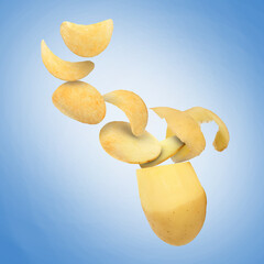 Raw potato turning into tasty crispy chips in air on blue gradient background