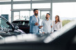 © Zamrznuti tonovi - Couple attentively viewing details on a car dealer's tablet.