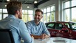 © Ruslan Gilmanshin - Two men sit at a table in a car dealership talking
