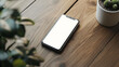© Elnare - Top view of a white smartphone on a wooden table.
