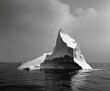© Goashape-Studio - Majestic Iceberg in Black and White: An imposing iceberg rises from the icy waters, its stark silhouette set against a dramatic sky, a powerful image of nature's grandeur and the fragility of our plan