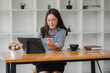 © Wicitr - Smiling at Success: A young woman in a stylish office setting, beaming as she uses her tablet. The scene captures the joy and focus of modern work. It's a perfect image for showcasing productivity, te