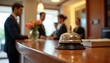 © abu - Elegant hotel reception bell on a wooden counter, embodying hospitality and professionalism.
