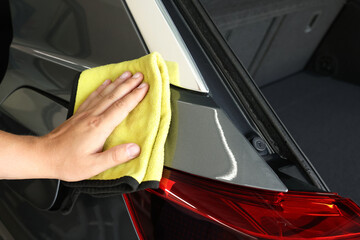 Man wiping auto with rag at car wash, closeup