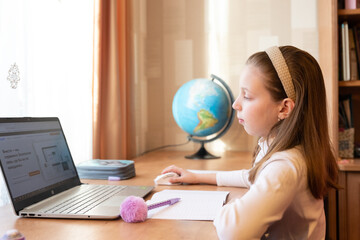 Pretty stylish schoolgirl studying homework math during her online lesson at home, social distance during quarantine,online education concept, home schooler.Online Lesson.