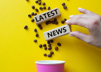 Latest News symbol. Concept word Latest News on wooden blocks. Businessman hand. Beautiful yellow background with coffee cup. Business and Latest News concept. Copy space