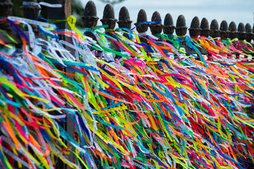 Several colorful ribbons of remembrance attached to the fence of the Senhor do Bonfim church in the city of Salvador, Bahia.