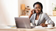 © Prostock-studio - Portrait of black female entrepreneur talking on mobile phone, taking notes and smiling to camera