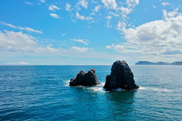 Aerial view Top down seashore. Waves crashing on rock cliff. Beautiful sea surface in sunny day summer background Amazing seascape top view seacoast