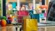 © Sam - Colorful shopping bags in a mini shopping cart with a laptop in the background. Perfect for online shopping.