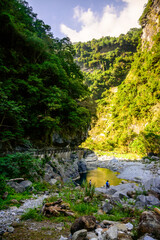 A vibrant blue river flowing through a dramatic mountain canyon, showcasing the stunning natural beauty and dynamic landscape on Shakadang Trail in Taroko National Park, Hualien, Taiwan