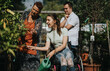 © qunica.com - An elderly woman, a girl in a wheelchair, and a boy with Down syndrome enjoy gardening together, showcasing inclusivity and connection across generations in a sunny garden.